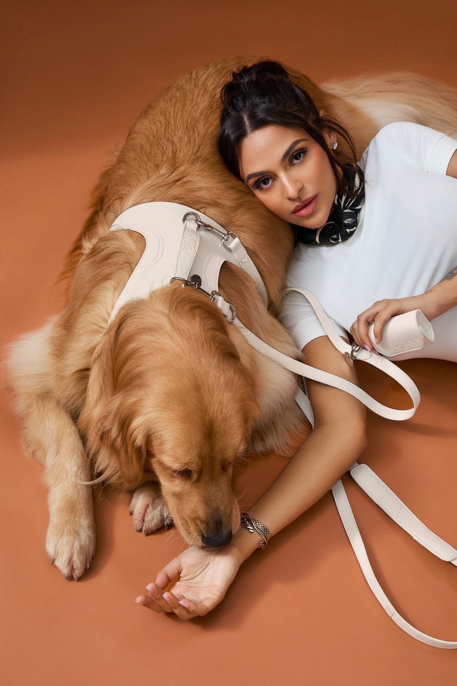 Guia ARIA na cor off white em uso, com o cachorro deitado ao lado da tutora