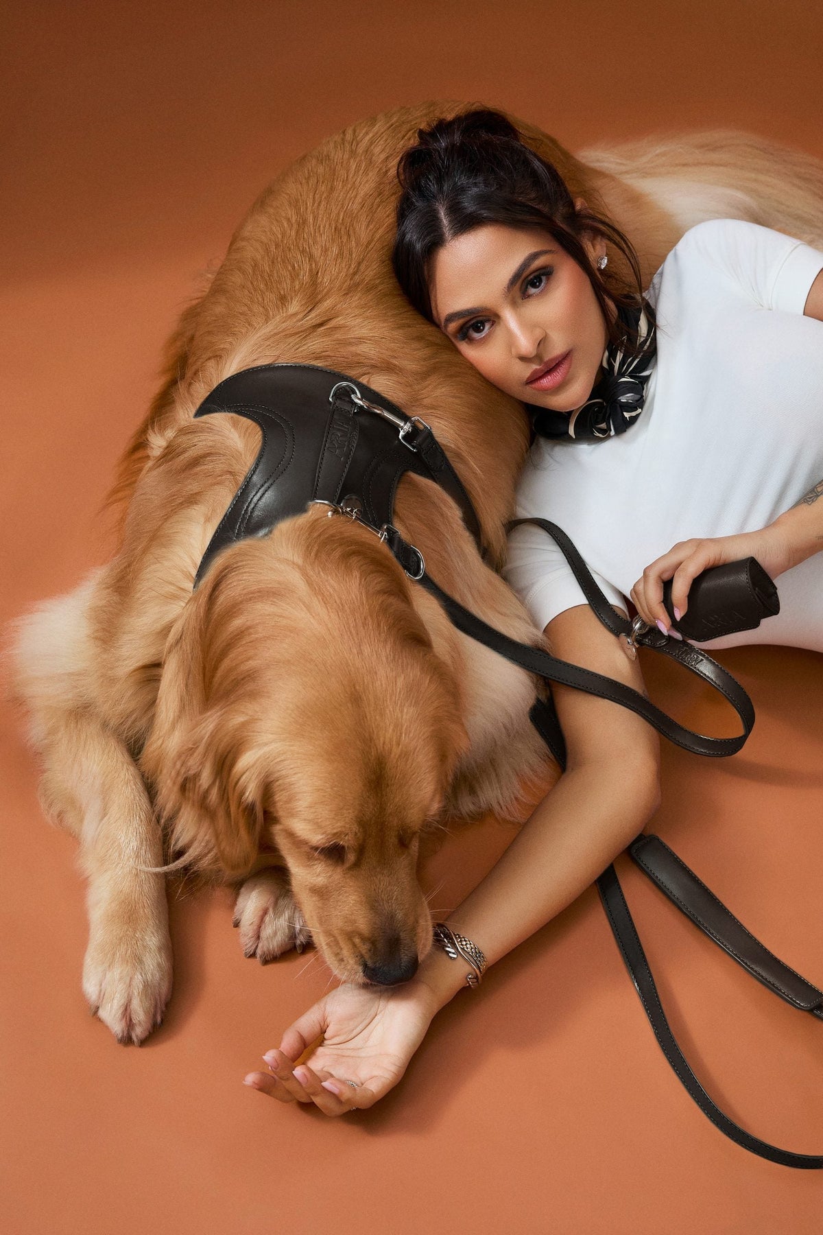 Guia ARIA na cor preta em uso, com o cachorro deitado ao lado da tutora